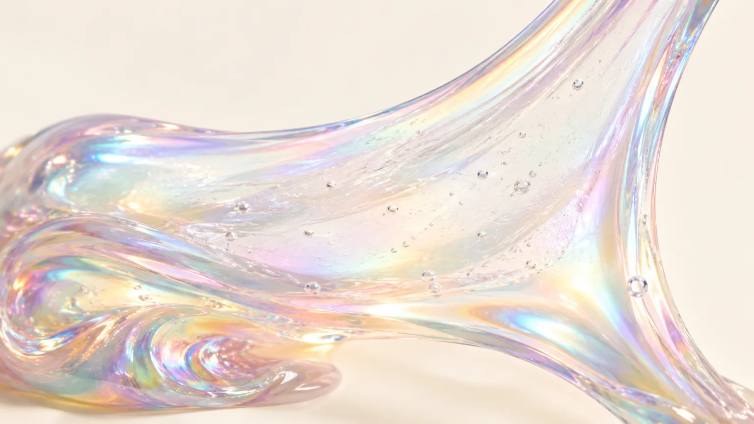 Iridescent slime stretched into a thin translucent sheet on a cream studio background